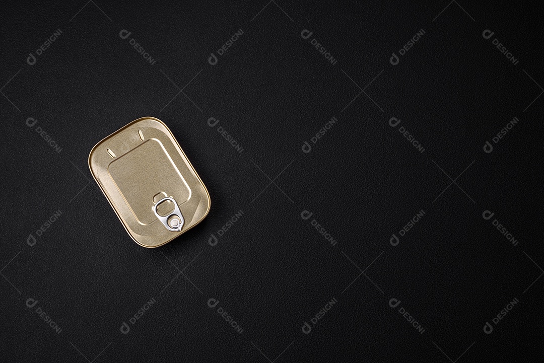 Lata retangular de estanho ou alumínio de alimentos enlatados com uma chave sobre um fundo escuro de concreto