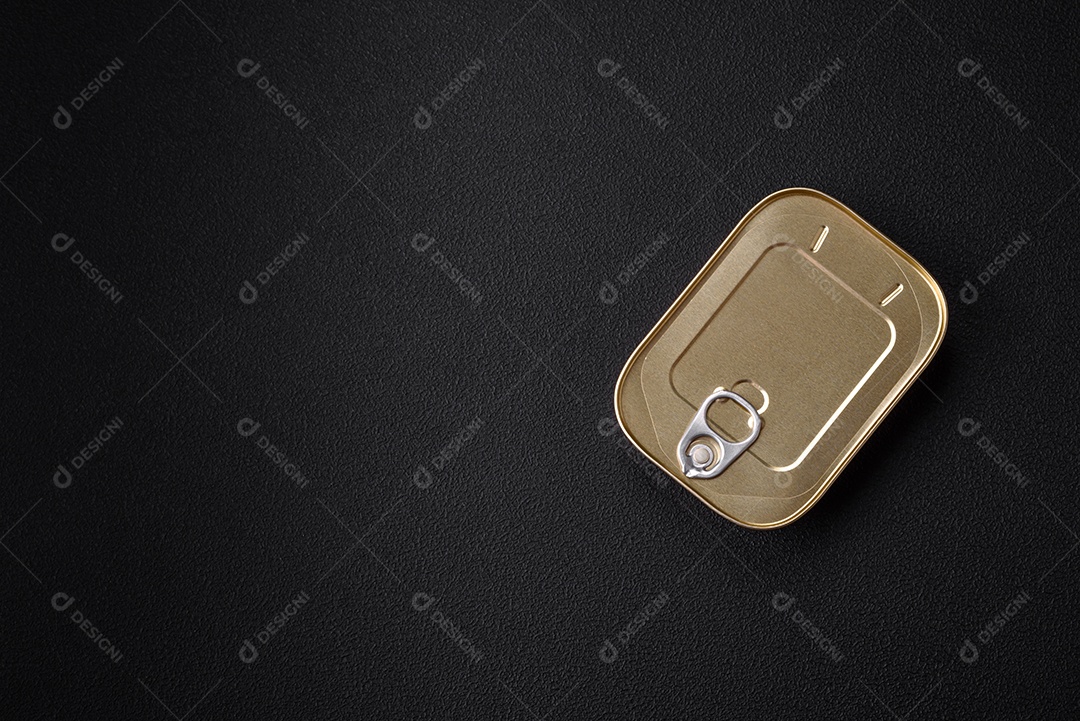 Lata retangular de estanho ou alumínio de alimentos enlatados com uma chave sobre um fundo escuro de concreto