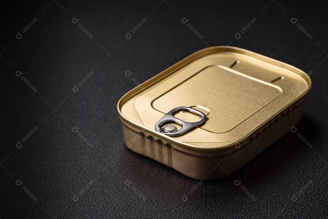 Lata retangular de estanho ou alumínio de alimentos enlatados com uma chave sobre um fundo escuro de concreto