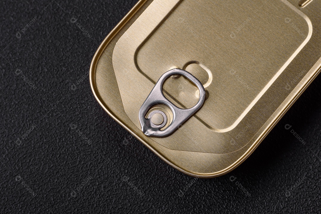 Lata retangular de estanho ou alumínio de alimentos enlatados com uma chave sobre um fundo escuro de concreto