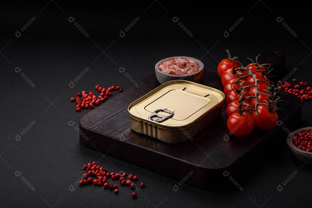 Lata retangular de estanho ou alumínio de alimentos enlatados com uma chave sobre um fundo escuro de concreto