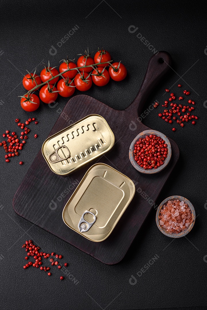 Lata retangular de estanho ou alumínio de alimentos enlatados com uma chave sobre um fundo escuro de concreto