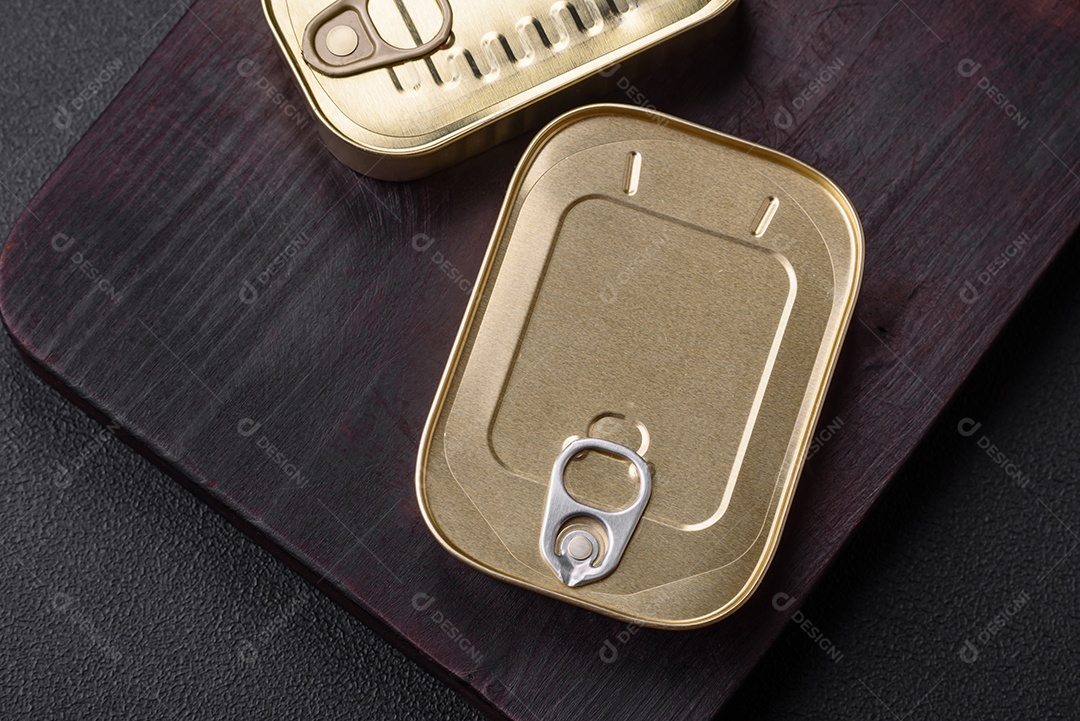 Lata retangular de estanho ou alumínio de alimentos enlatados com uma chave sobre um fundo escuro de concreto