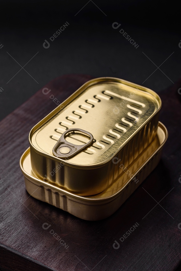 Lata retangular de estanho ou alumínio de alimentos enlatados com uma chave sobre um fundo escuro de concreto
