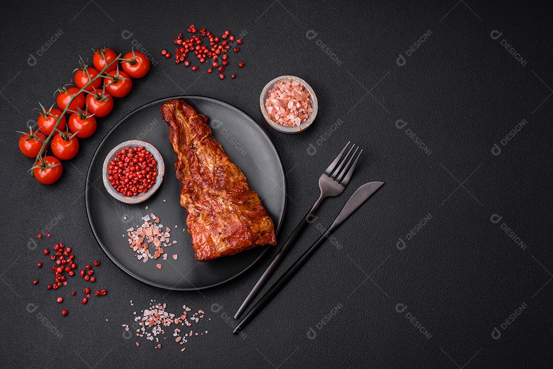 Deliciosas costelas de porco grelhadas ou defumadas com sal, especiarias e ervas em fundo de concreto texturizado