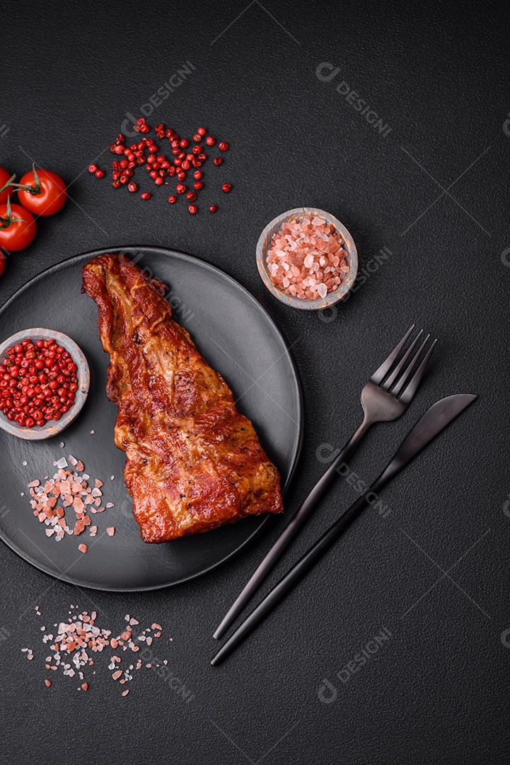 Deliciosas costelas de porco grelhadas ou defumadas com sal, especiarias e ervas em fundo de concreto texturizado