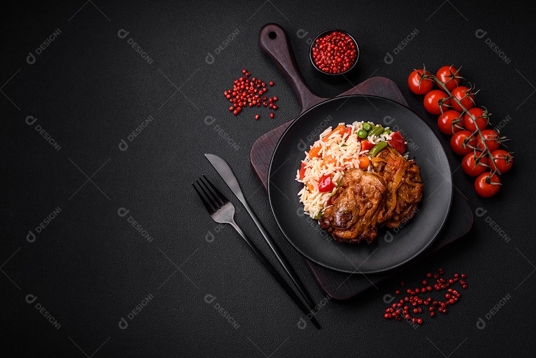 Delicioso arroz cozido com pimentão, ervilha, feijão de espargos e cenoura e frango frito sobre fundo de concreto texturizado