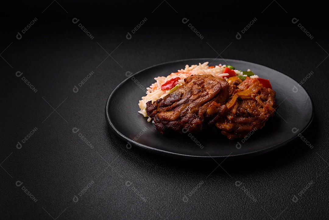 Delicioso arroz cozido com pimentão, ervilha, feijão de espargos e cenoura e frango frito sobre fundo de concreto texturizado