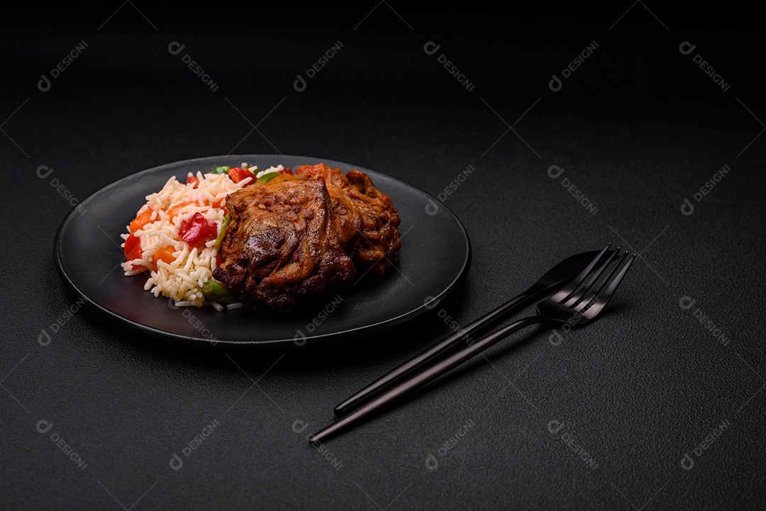 Delicioso arroz cozido com pimentão, ervilha, feijão de espargos e cenoura e frango frito sobre fundo de concreto texturizado