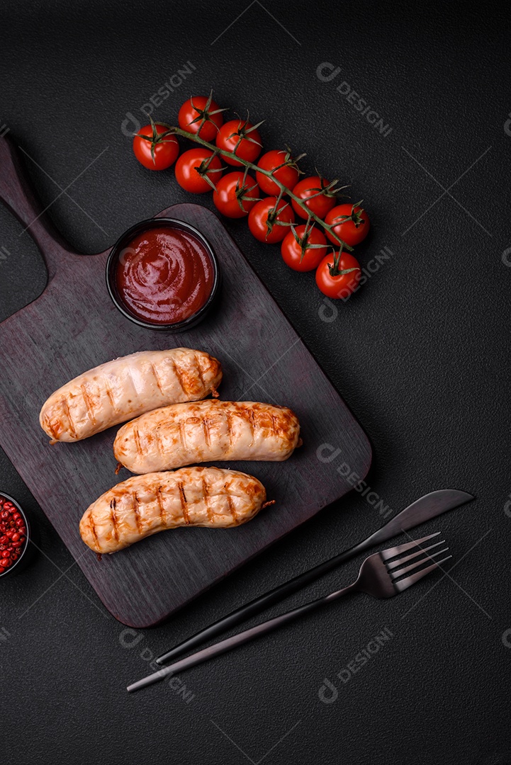 Deliciosas salsichas grelhadas de frango ou carne de porco com sal, especiarias e ervas sobre um fundo de concreto texturizado