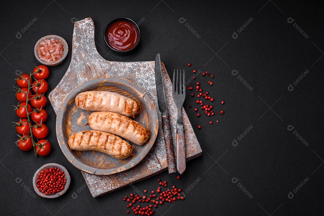 Deliciosas salsichas grelhadas de frango ou carne de porco com sal, especiarias e ervas sobre um fundo de concreto texturizado