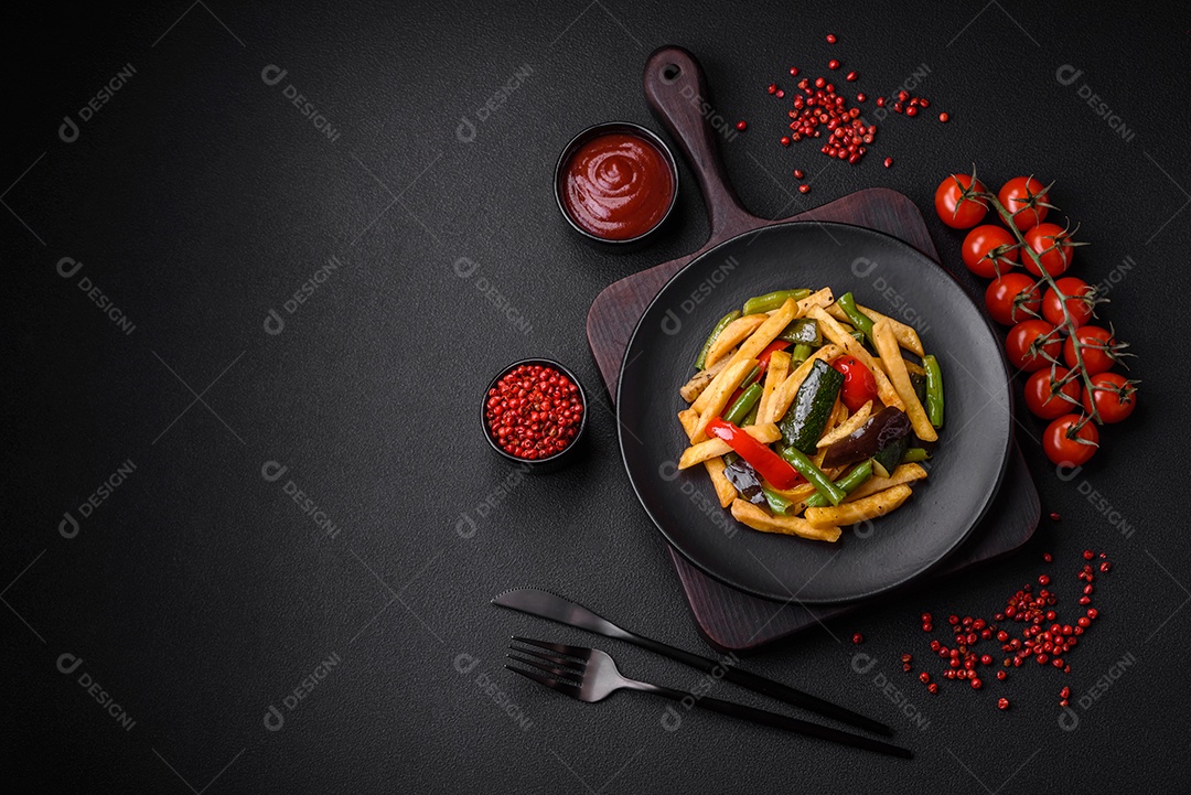 Deliciosas batatas fritas com pimentão, feijão de espargos, sal e especiarias em um prato sobre um fundo escuro de concreto