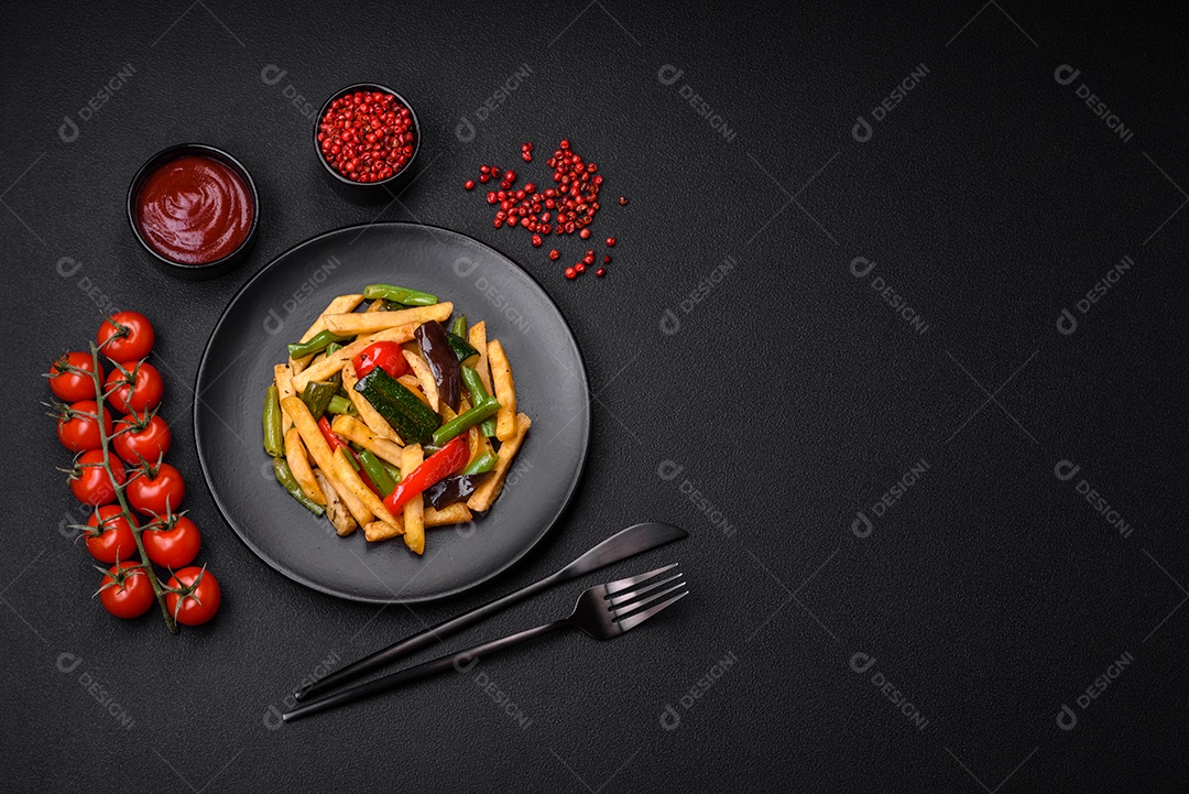 Deliciosas batatas fritas com pimentão, feijão de espargos, sal e especiarias em um prato sobre um fundo escuro de concreto