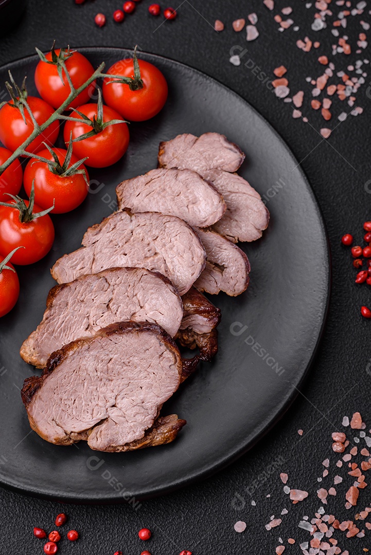 Delicioso bife com sal, especiarias e ervas em uma placa cerâmica sobre um fundo escuro de concreto