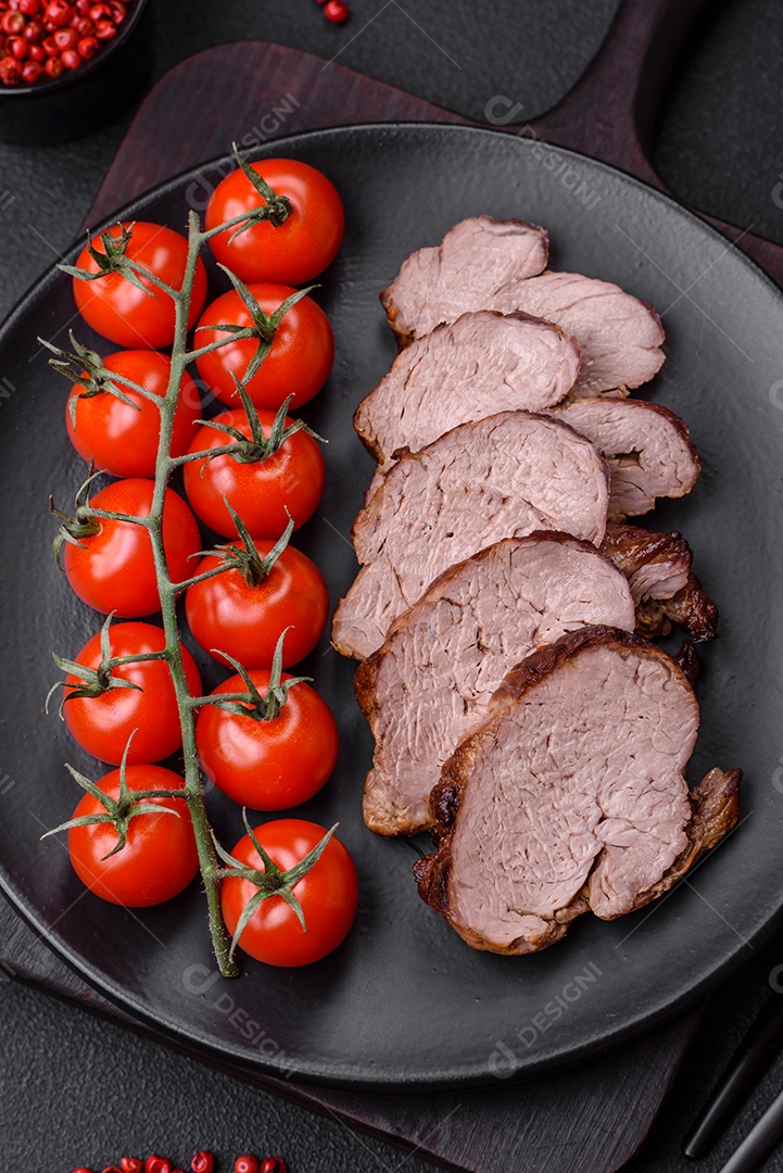 Delicioso bife com sal, especiarias e ervas em uma placa cerâmica sobre um fundo escuro de concreto