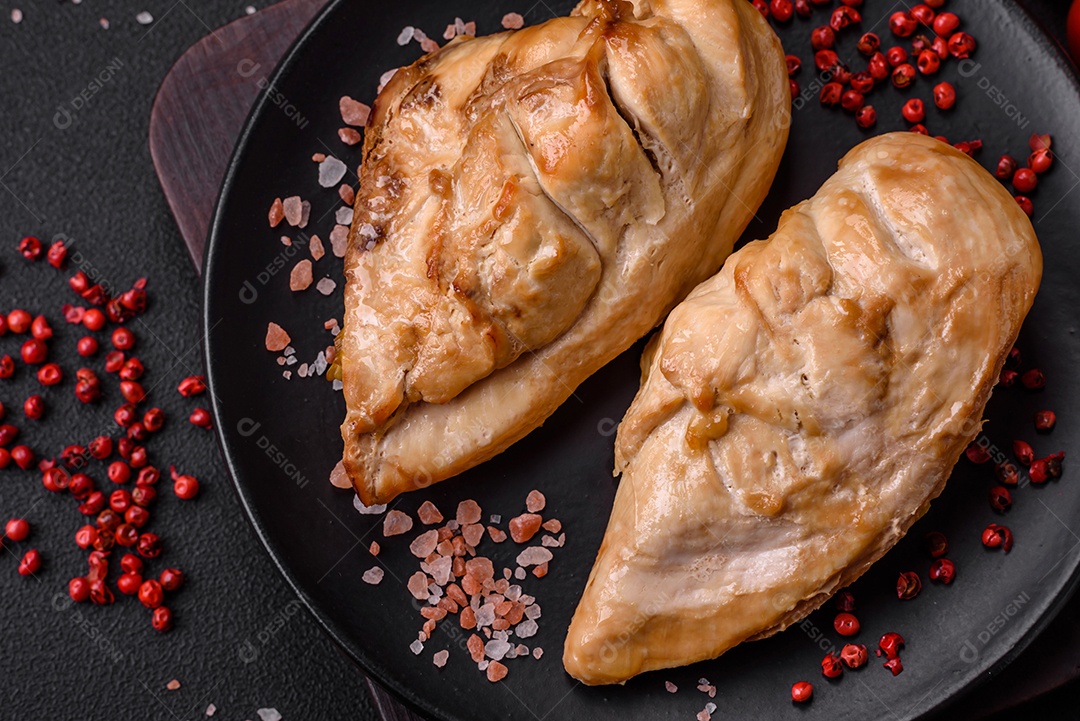 Delicioso bife com sal, especiarias e ervas em uma placa cerâmica sobre um fundo escuro de concreto