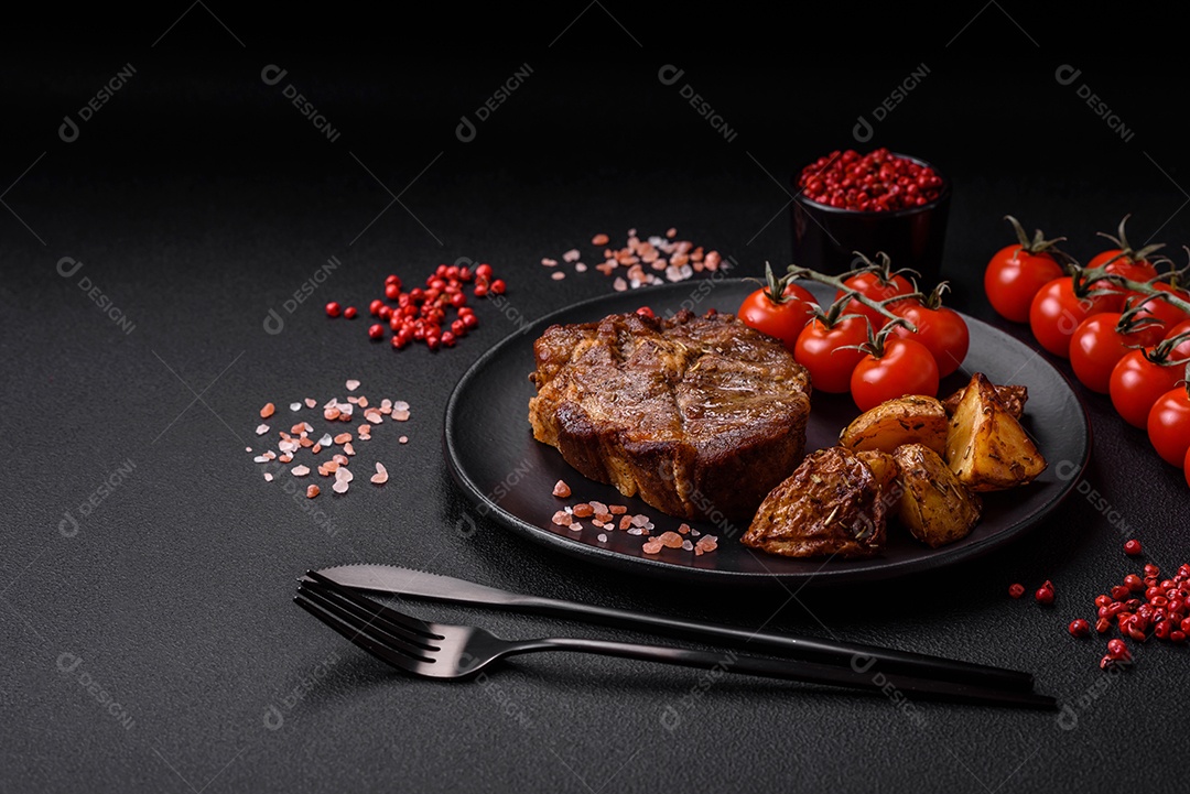 Delicioso bife com sal, especiarias e ervas em uma placa cerâmica sobre um fundo escuro de concreto