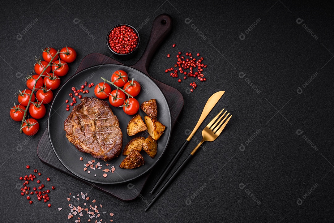 Delicioso bife com sal, especiarias e ervas em uma placa cerâmica sobre um fundo escuro de concreto