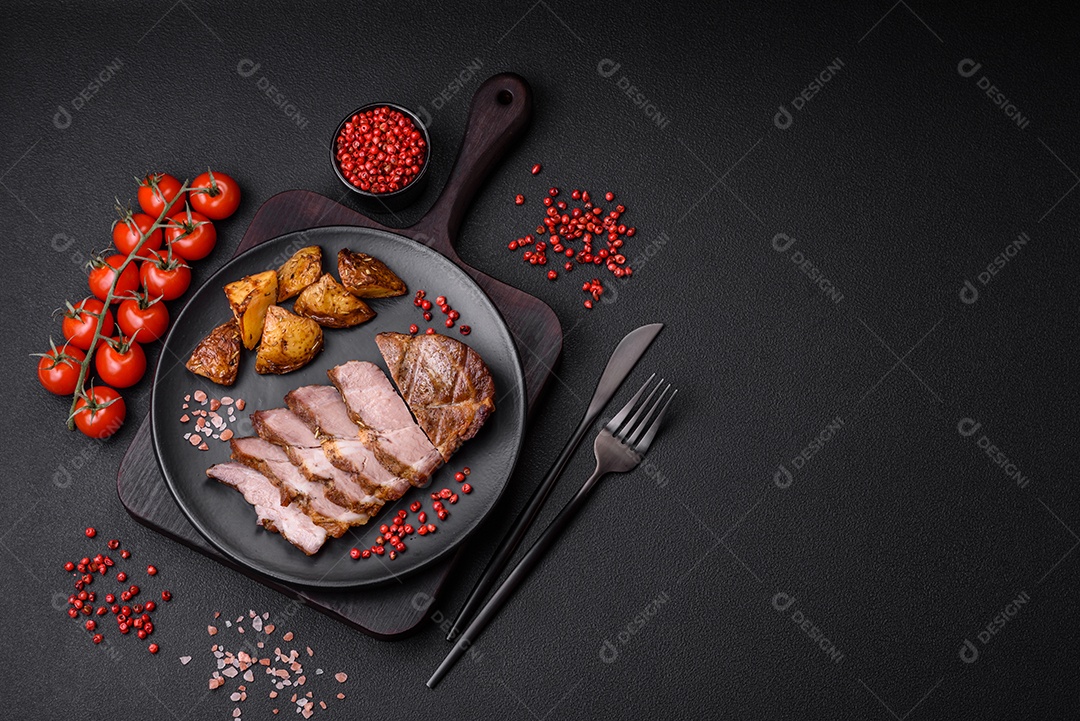 Delicioso bife com sal, especiarias e ervas em uma placa cerâmica sobre um fundo escuro de concreto