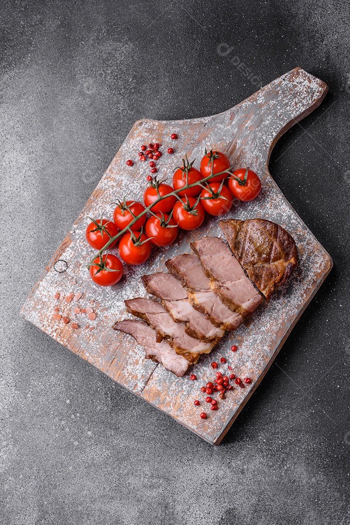 Delicioso bife com sal, especiarias e ervas em uma placa cerâmica sobre um fundo escuro de concreto
