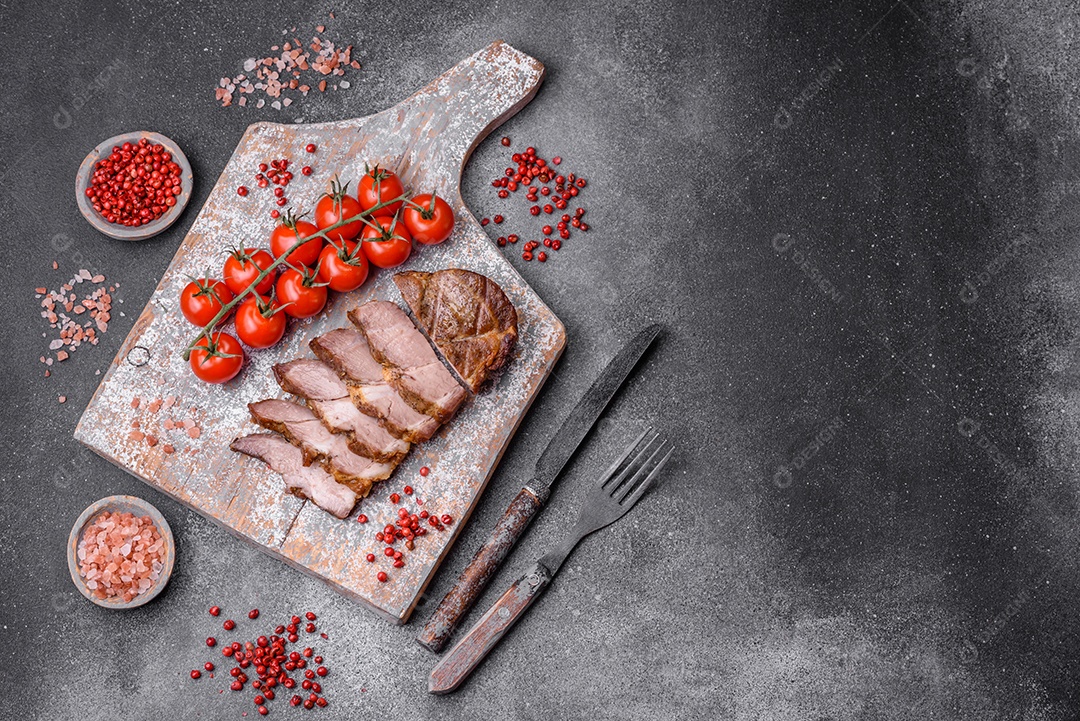 Delicioso bife com sal, especiarias e ervas em uma placa cerâmica sobre um fundo escuro de concreto