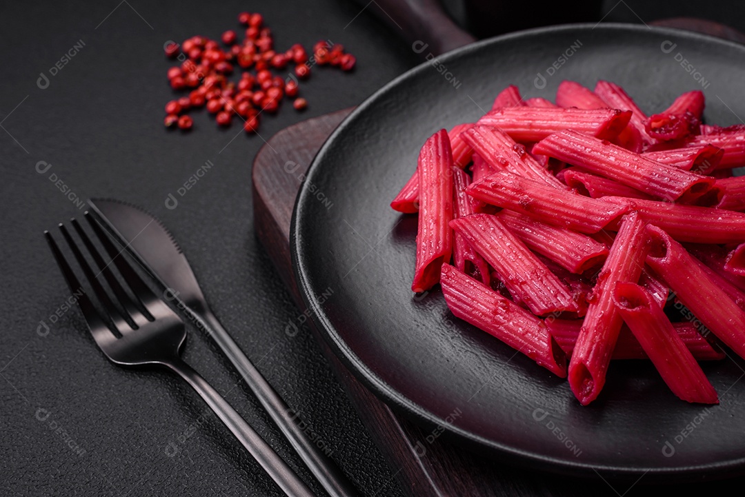 Deliciosa massa penne com beterraba, queijo, sal e especiarias sobre um fundo escuro de concreto