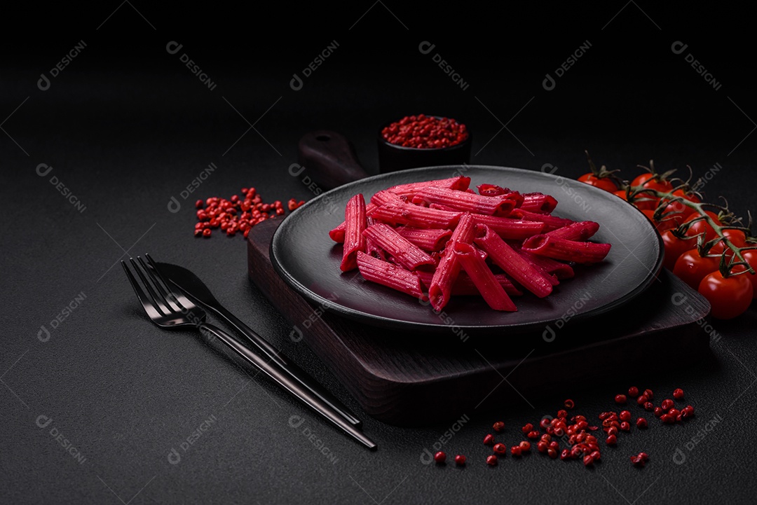 Deliciosa massa penne com beterraba, queijo, sal e especiarias sobre um fundo escuro de concreto