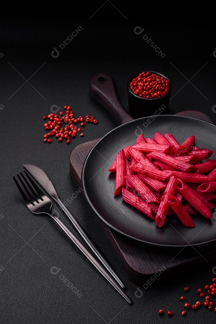 Deliciosa massa penne com beterraba, queijo, sal e especiarias sobre um fundo escuro de concreto