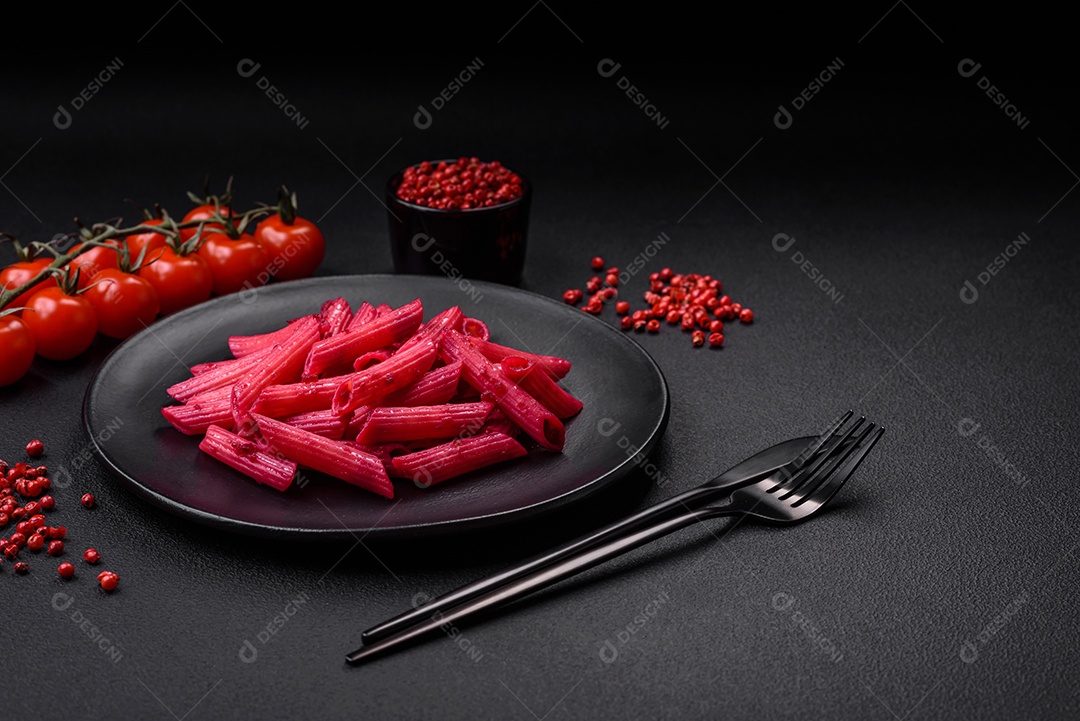 Deliciosa massa penne com beterraba, queijo, sal e especiarias sobre um fundo escuro de concreto