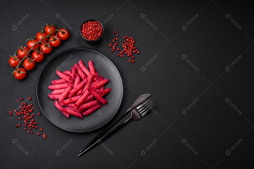 Deliciosa massa penne com beterraba, queijo, sal e especiarias sobre um fundo escuro de concreto