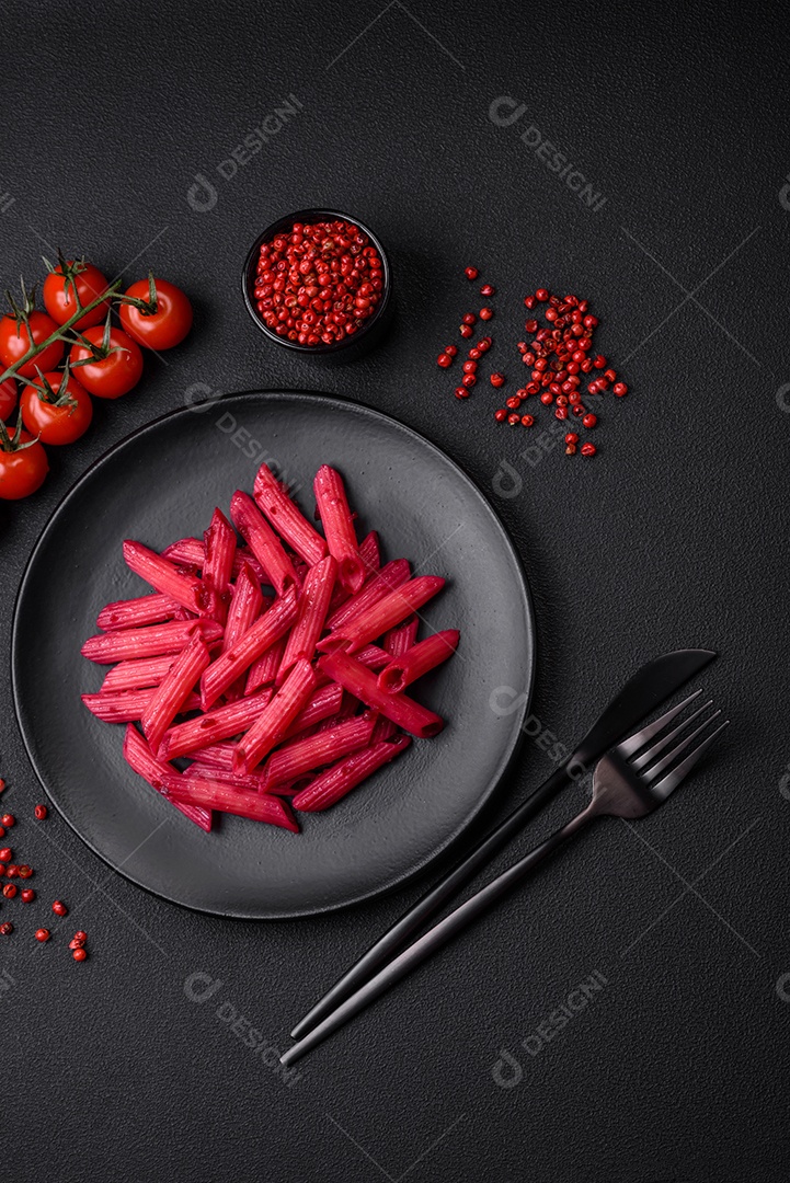 Deliciosa massa penne com beterraba, queijo, sal e especiarias sobre um fundo escuro de concreto