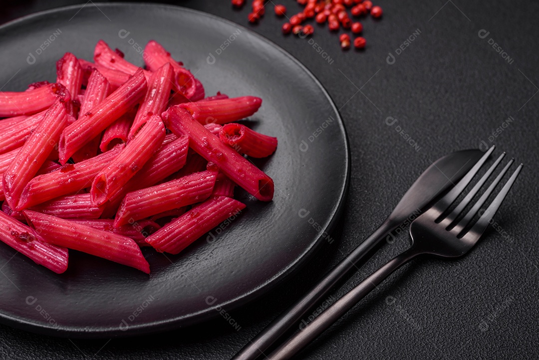 Deliciosa massa penne com beterraba, queijo, sal e especiarias sobre um fundo escuro de concreto