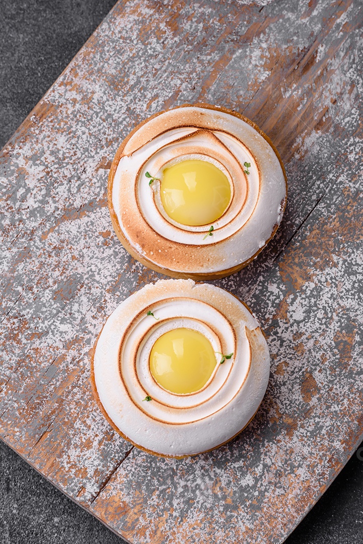 Deliciosa torta com recheio cítrico e creme de nozes sobre fundo de concreto texturizado