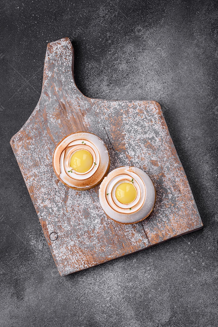 Deliciosa torta com recheio cítrico e creme de nozes sobre fundo de concreto texturizado