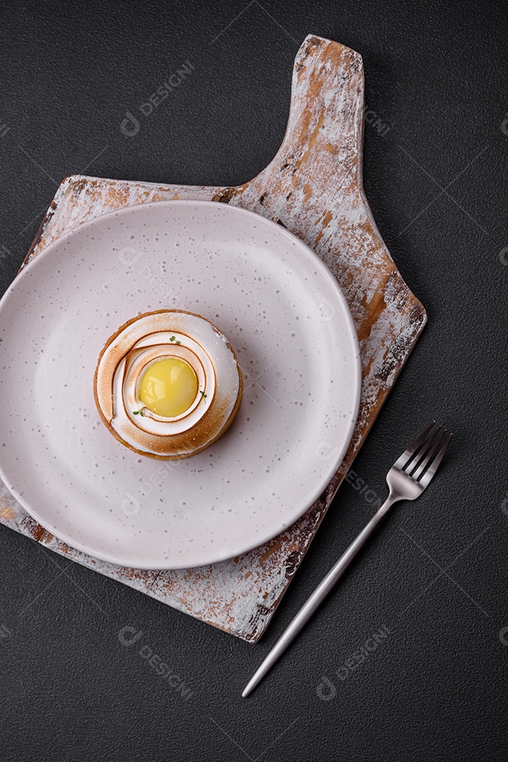 Deliciosa torta com recheio cítrico e creme de nozes sobre fundo de concreto texturizado