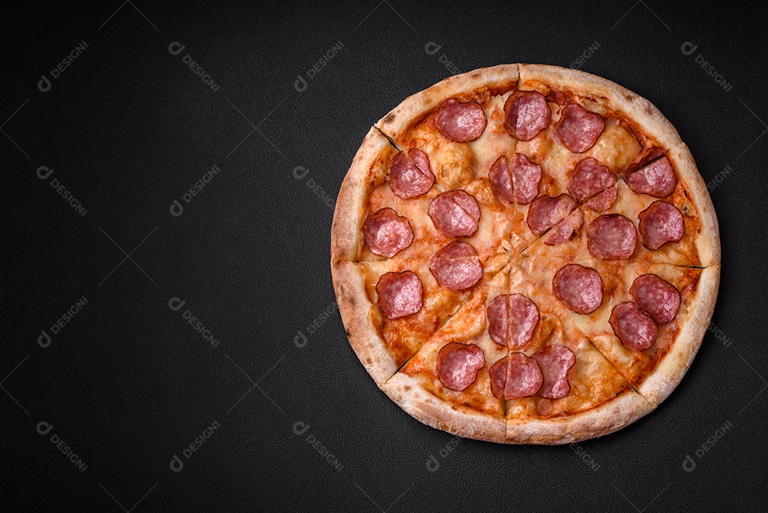 Pizza bávara com enchidos, tomates, queijo, sal e especiarias sobre um fundo escuro de concreto