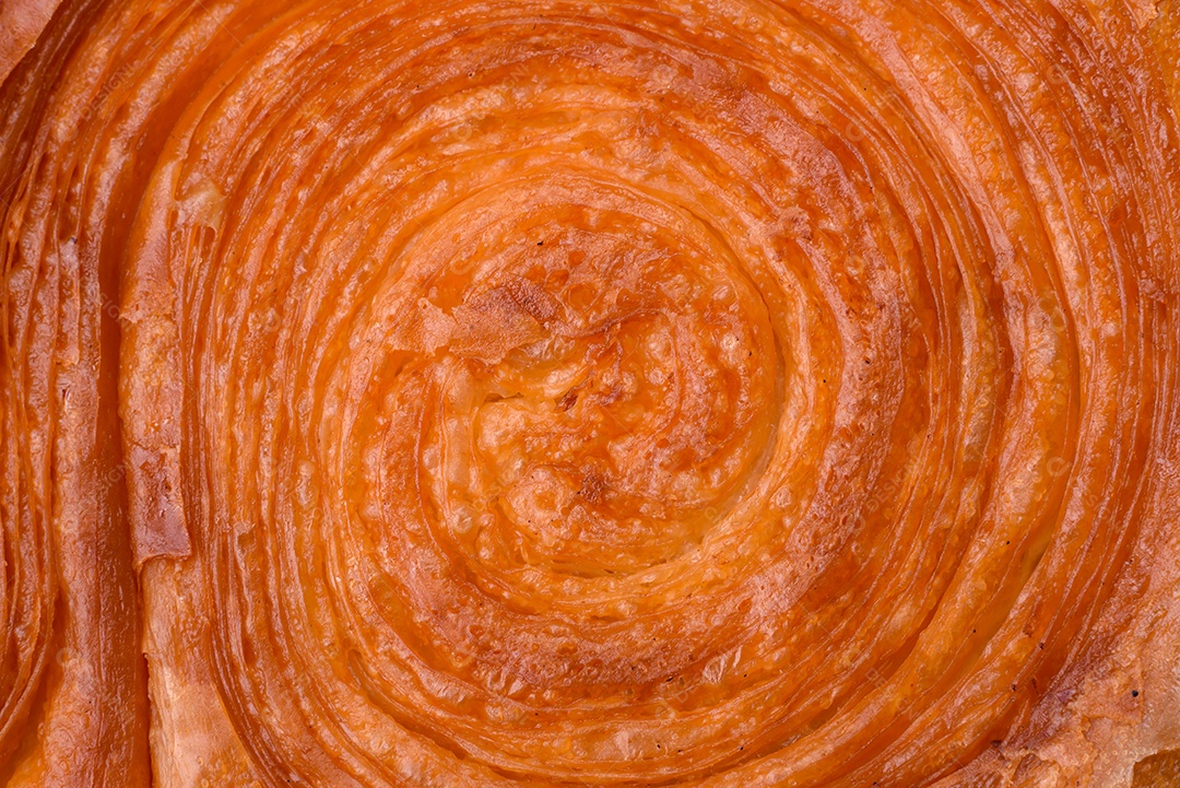 Croissant redondo de massa folhada com recheio de frutas cítricas ou rolo de Nova York sobre fundo escuro de concreto