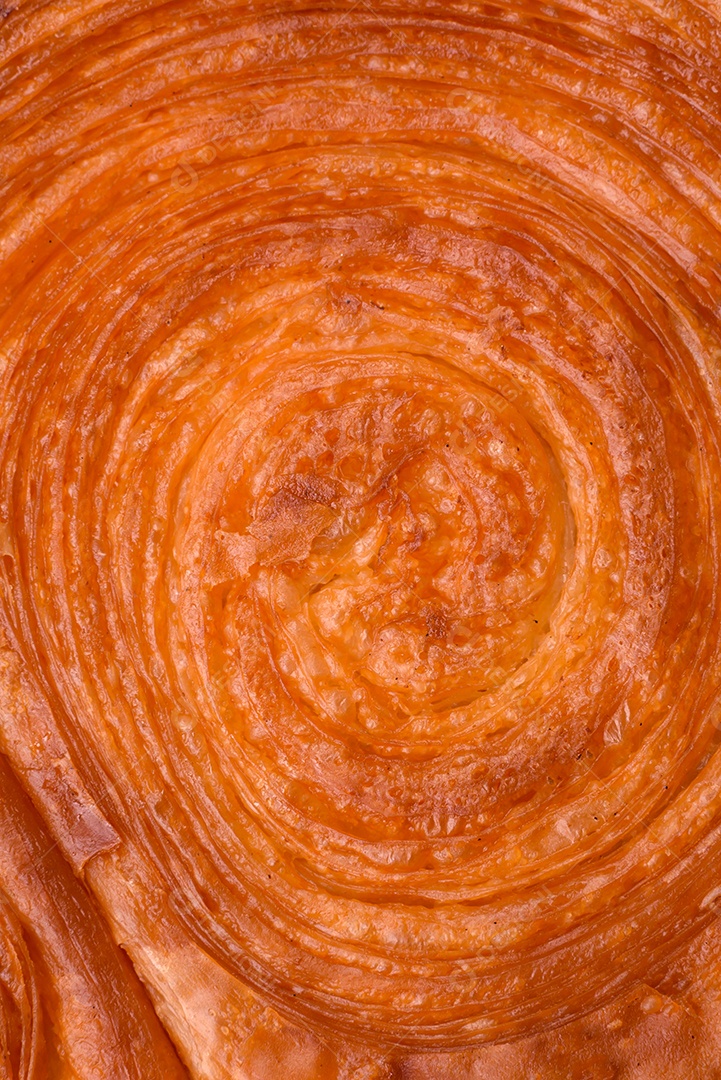 Croissant redondo de massa folhada com recheio de frutas cítricas ou rolo de Nova York sobre fundo escuro de concreto