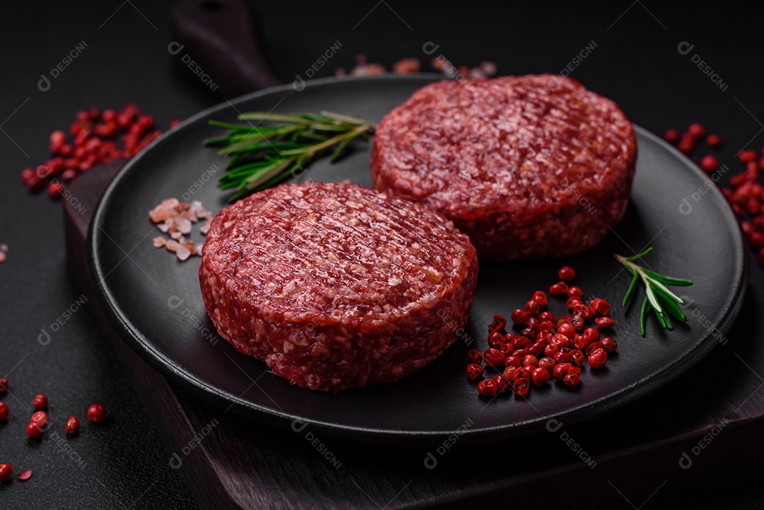 Hambúrguer de carne moída crua fresca com sal e especiarias em fundo de concreto texturizado