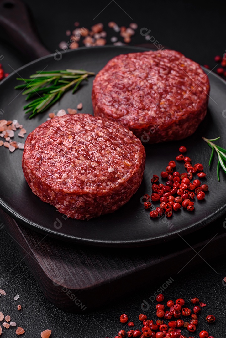 Hambúrguer de carne moída crua fresca com sal e especiarias em fundo de concreto texturizado