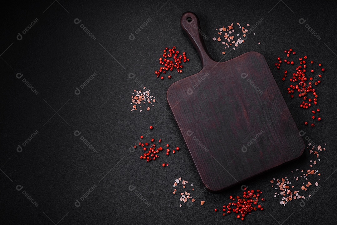 Ingredientes para cozinhar tomate cereja, sal, especiarias e ervas sobre um fundo escuro de concreto