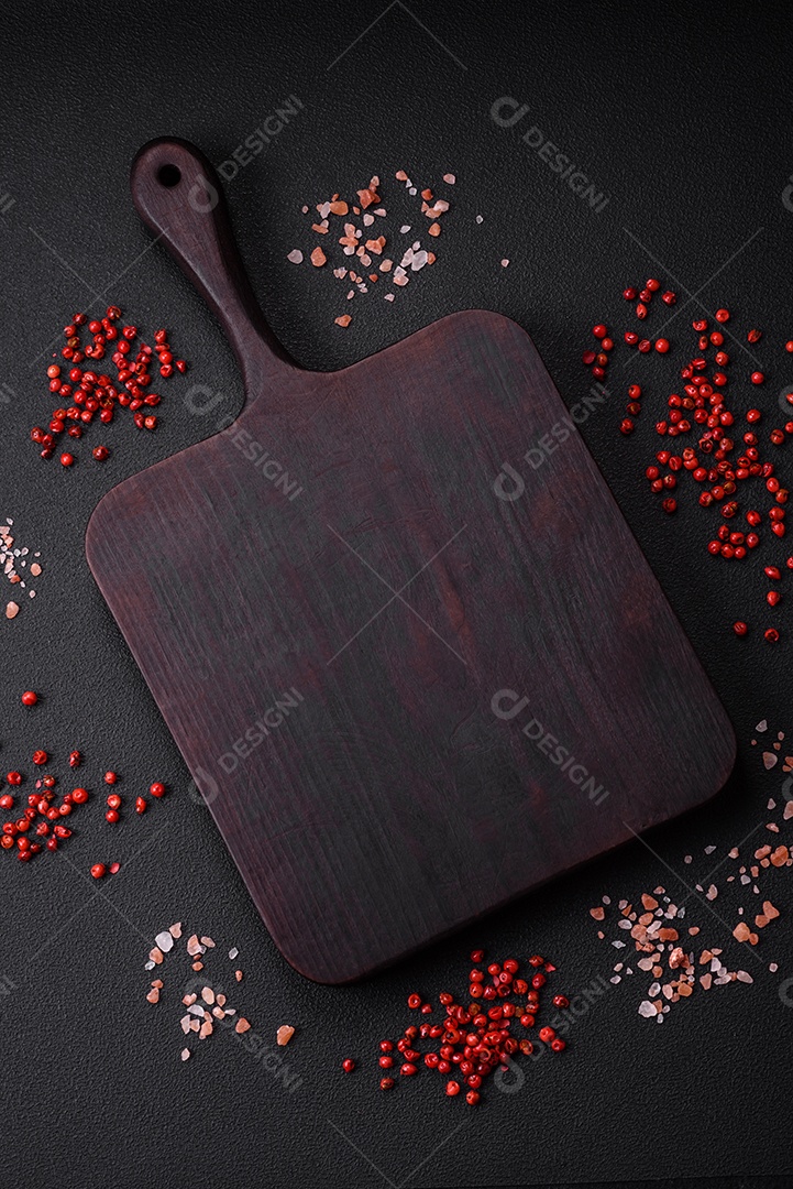 Ingredientes para cozinhar tomate cereja, sal, especiarias e ervas sobre um fundo escuro de concreto