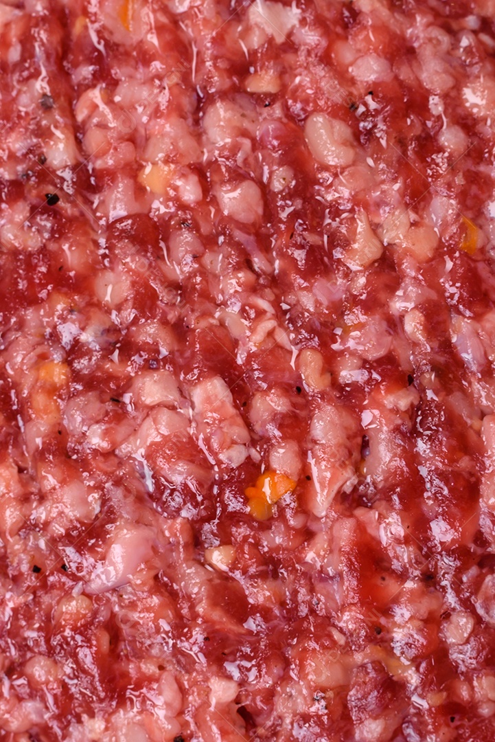 Hambúrguer de carne moída crua fresca com sal e especiarias em fundo de concreto texturizado