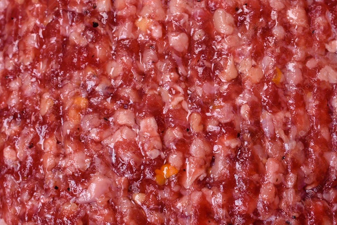 Hambúrguer de carne moída crua fresca com sal e especiarias em fundo de concreto texturizado