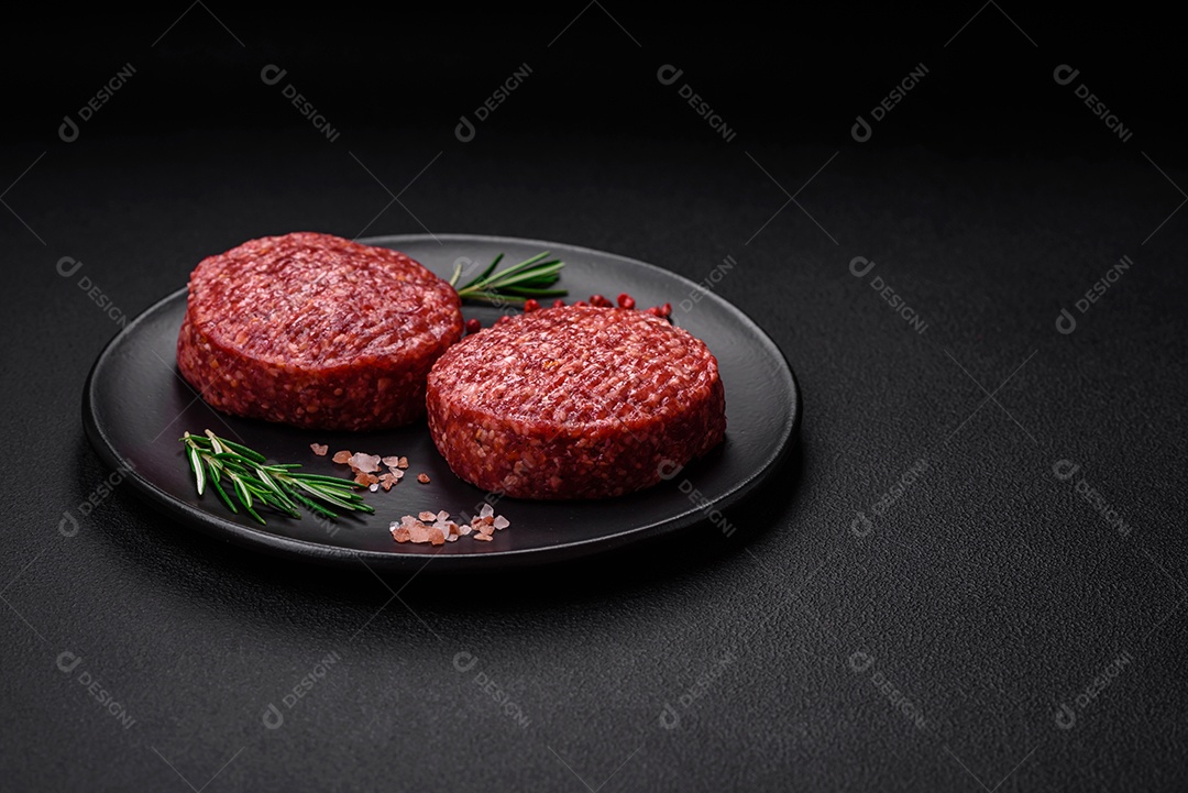 Hambúrguer de carne moída crua fresca com sal e especiarias em fundo de concreto texturizado