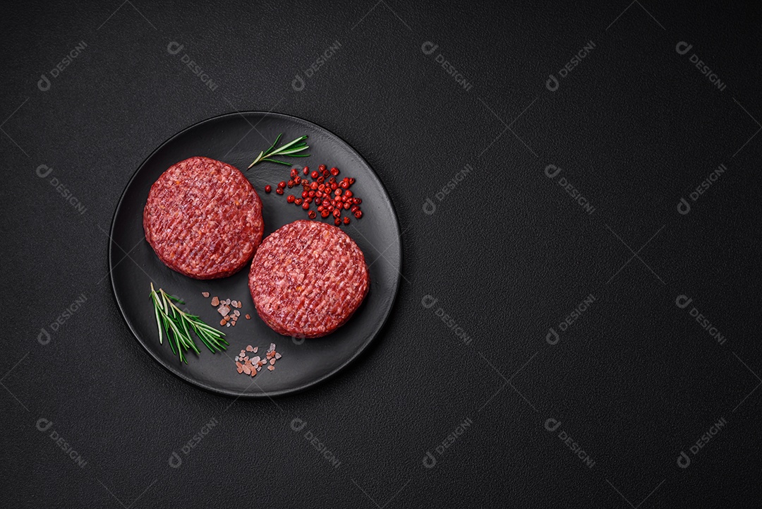 Hambúrguer de carne moída crua fresca com sal e especiarias em fundo de concreto texturizado