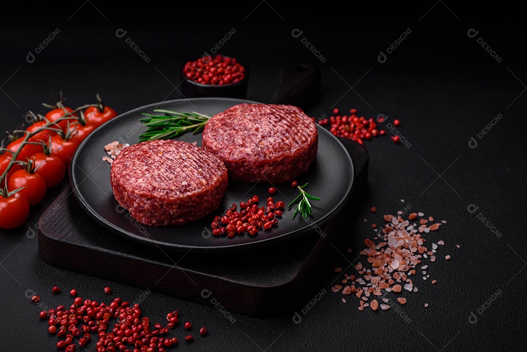 Hambúrguer de carne moída crua fresca com sal e especiarias em fundo de concreto texturizado