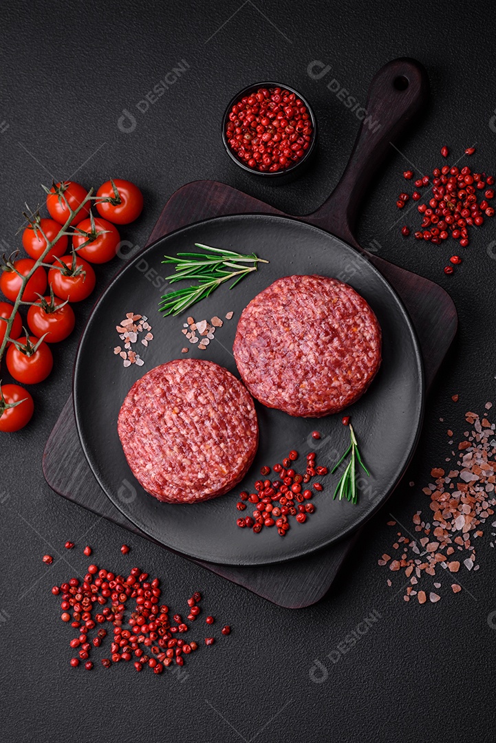 Hambúrguer de carne moída crua fresca com sal e especiarias em fundo de concreto texturizado