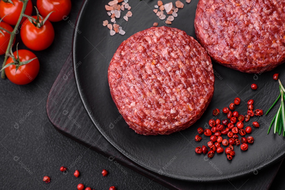 Hambúrguer de carne moída crua fresca com sal e especiarias em fundo de concreto texturizado