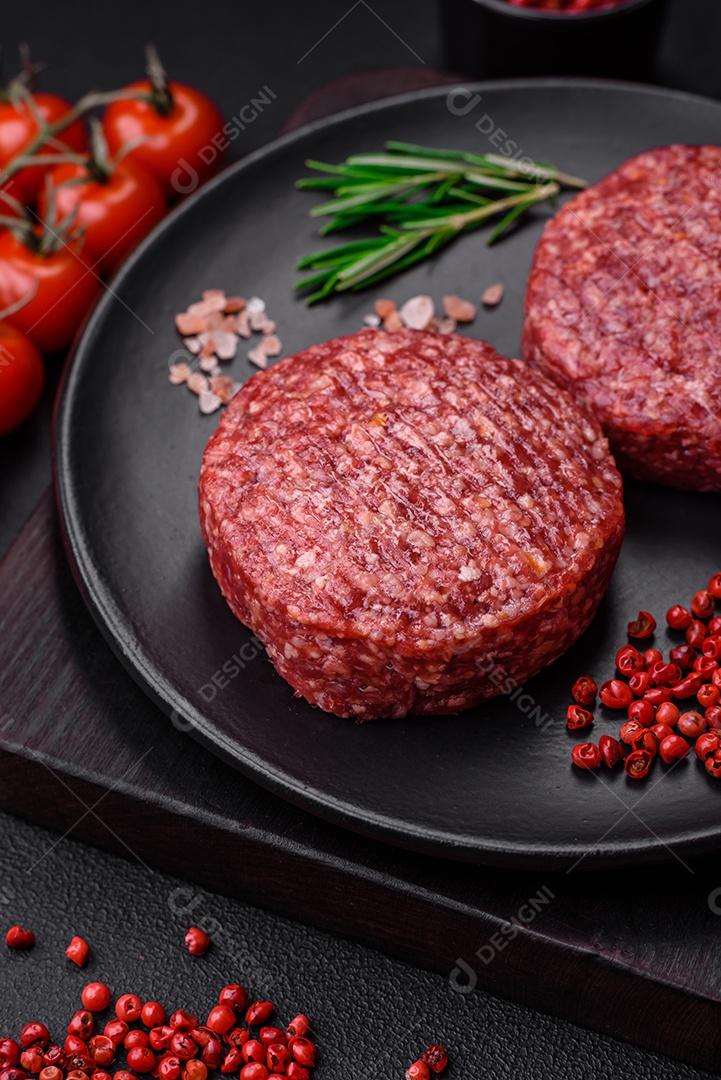 Hambúrguer de carne moída crua fresca com sal e especiarias em fundo de concreto texturizado